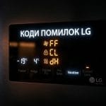 Цифрова панель керування холодильника LG із символами кодів помилок на темному фоні.